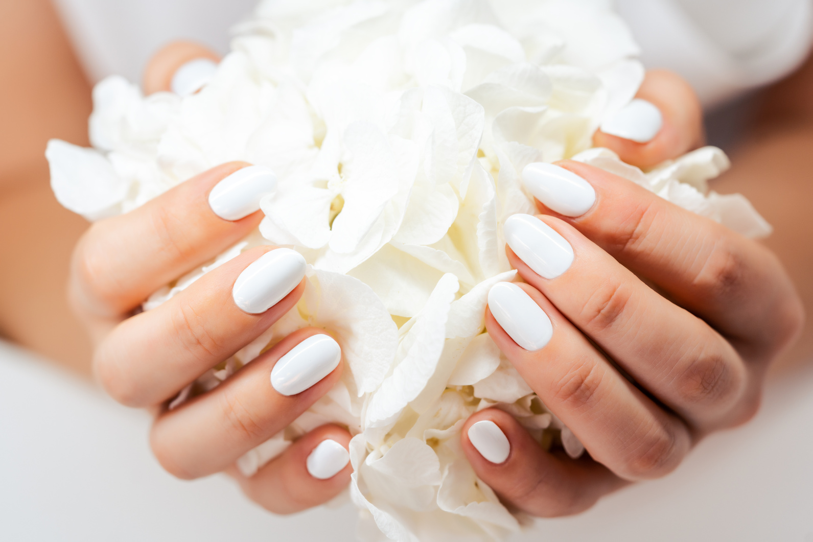 Closeup of Hands of a Young Woman with White Nails